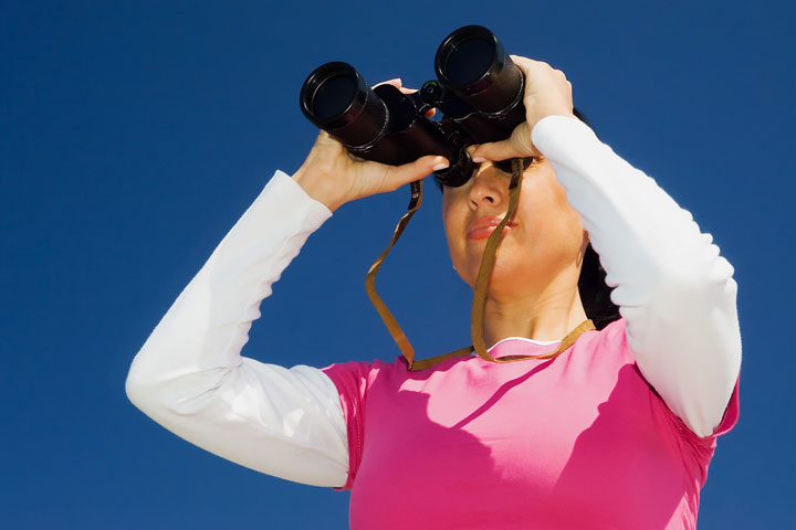 a woman looking through binoculars (large image)