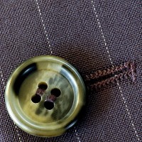 a button and buttonhole on a pin-striped suit