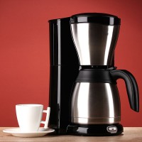 a coffeemaker with a coffee cup and saucer