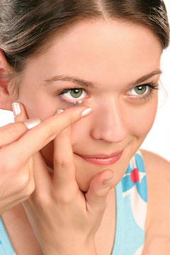 a young woman inserting a contact lens