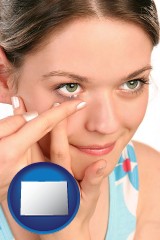 colorado a young woman inserting a contact lens