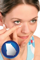 georgia map icon and a young woman inserting a contact lens