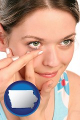 iowa map icon and a young woman inserting a contact lens