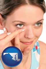 maryland map icon and a young woman inserting a contact lens