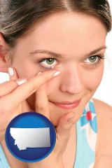 montana map icon and a young woman inserting a contact lens