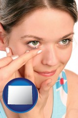 wyoming map icon and a young woman inserting a contact lens