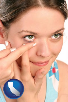 a young woman inserting a contact lens - with California icon