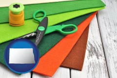 north-dakota map icon and craft supplies (colorful felt and a pair of scissors)