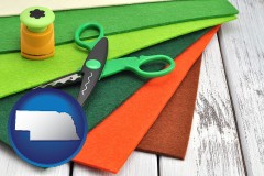 nebraska map icon and craft supplies (colorful felt and a pair of scissors)
