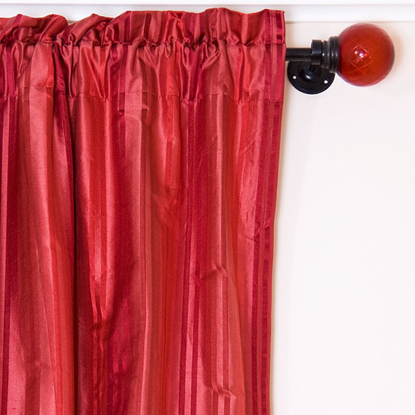 red drapes hanging from a drapery rod (large image)