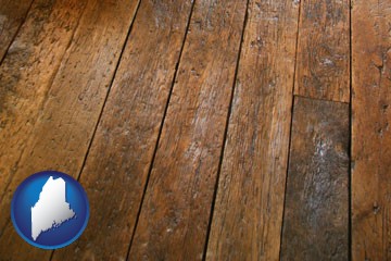 a distressed wood floor - with Maine icon