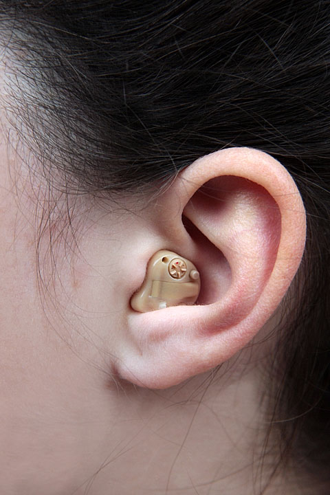 a woman wearing a hearing aid in her left ear (large image)