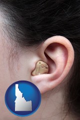 idaho map icon and a woman wearing a hearing aid in her left ear
