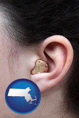 massachusetts map icon and a woman wearing a hearing aid in her left ear