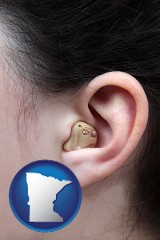 minnesota map icon and a woman wearing a hearing aid in her left ear