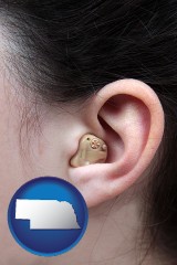 nebraska map icon and a woman wearing a hearing aid in her left ear