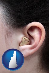 new-hampshire map icon and a woman wearing a hearing aid in her left ear