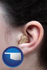oklahoma map icon and a woman wearing a hearing aid in her left ear