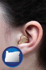 oregon map icon and a woman wearing a hearing aid in her left ear