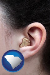 south-carolina map icon and a woman wearing a hearing aid in her left ear