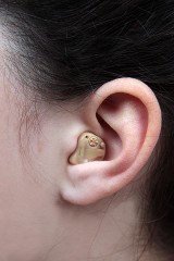 a woman wearing a hearing aid in her left ear