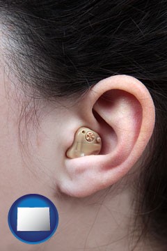 a woman wearing a hearing aid in her left ear - with Colorado icon