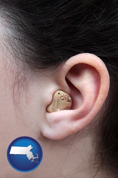 a woman wearing a hearing aid in her left ear - with Massachusetts icon