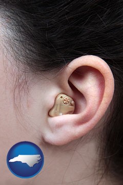 a woman wearing a hearing aid in her left ear - with North Carolina icon