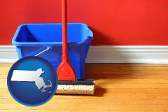 massachusetts map icon and a bucket and mop on a hardwood floor