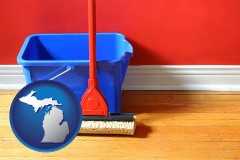 michigan map icon and a bucket and mop on a hardwood floor