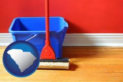 south-carolina map icon and a bucket and mop on a hardwood floor