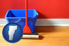 vermont map icon and a bucket and mop on a hardwood floor