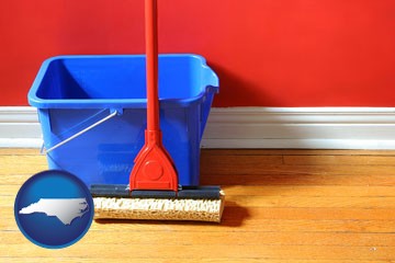 a bucket and mop on a hardwood floor - with North Carolina icon