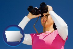 iowa map icon and a woman looking through binoculars