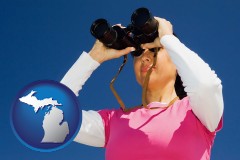 michigan map icon and a woman looking through binoculars