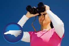 north-carolina map icon and a woman looking through binoculars
