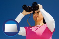 north-dakota map icon and a woman looking through binoculars