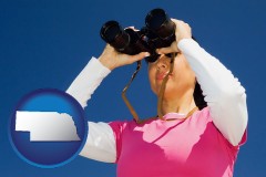 nebraska map icon and a woman looking through binoculars