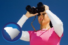 south-carolina map icon and a woman looking through binoculars