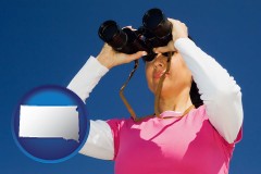 south-dakota map icon and a woman looking through binoculars