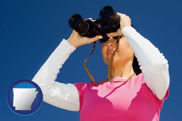 a woman looking through binoculars - with Arkansas icon