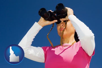 a woman looking through binoculars - with Idaho icon