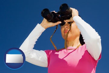 a woman looking through binoculars - with Kansas icon