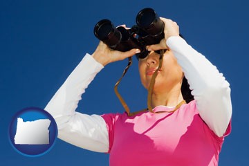 a woman looking through binoculars - with Oregon icon
