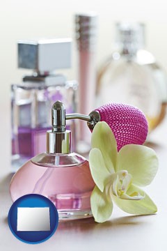 a perfume bottle, with atomizer, and an orchid flower - with Colorado icon