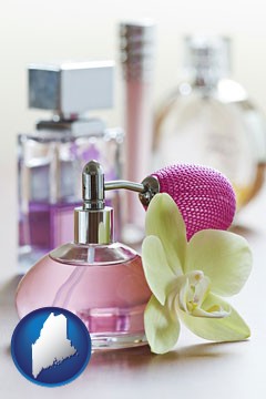 a perfume bottle, with atomizer, and an orchid flower - with Maine icon