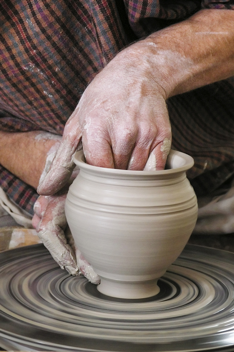 a potter making pottery on a pottery wheel (large image)