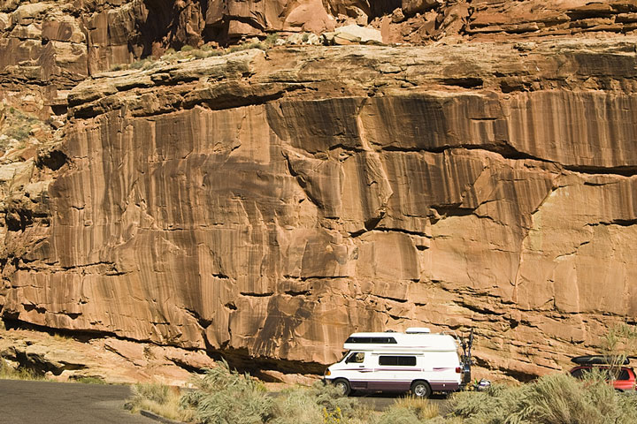 camper parked at the base of a cliff in Utah