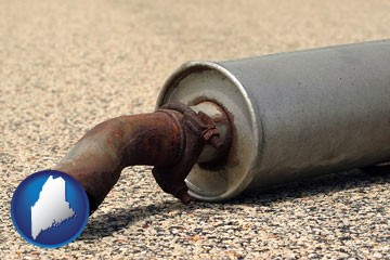 a rusty muffler and tailpipe - with Maine icon