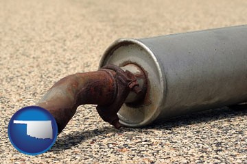 a rusty muffler and tailpipe - with Oklahoma icon